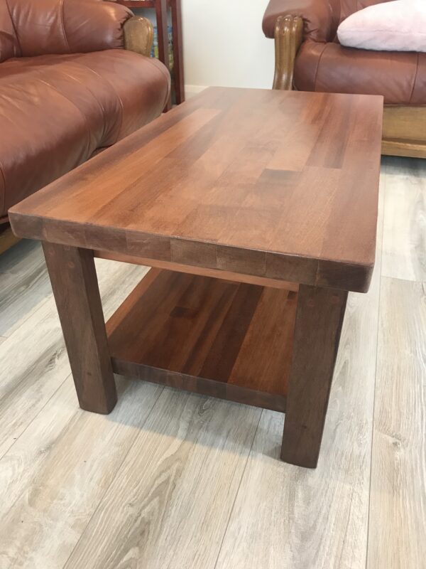A dark-stained solid wood coffee table we made, in a living room